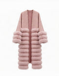 A long open-front cardigan in dusty pink, featuring a smooth knit upper section, a thick faux-fur collar, and stacked faux-fur sleeve cuffs and hem, with small metallic studs along the front opening.