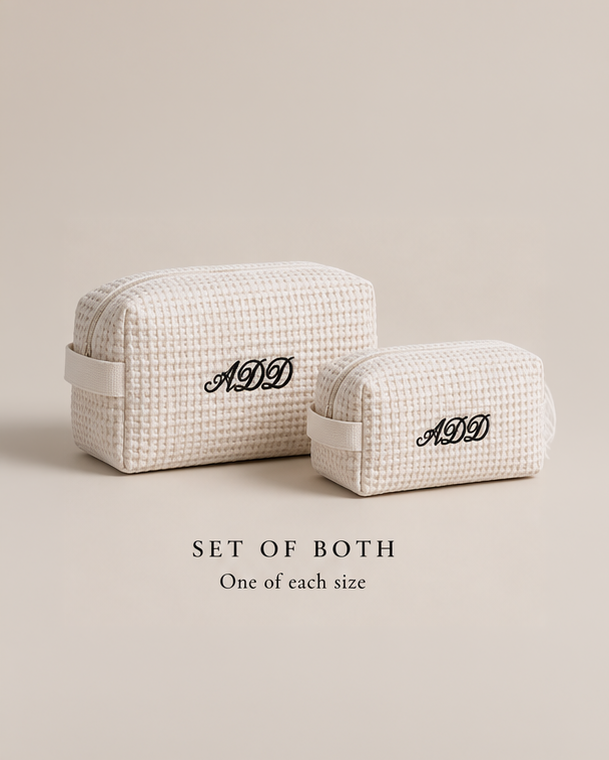 Two cream-colored woven cosmetic pouches with black embroidered monogram 'ADD' on the front, displayed on a neutral beige background with text reading 'SET OF BOTH One of each size'.