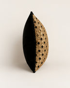 A decorative oval throw pillow with a black velvet side and a gold metallic geometric lattice pattern on the front, shown against a plain off-white background.