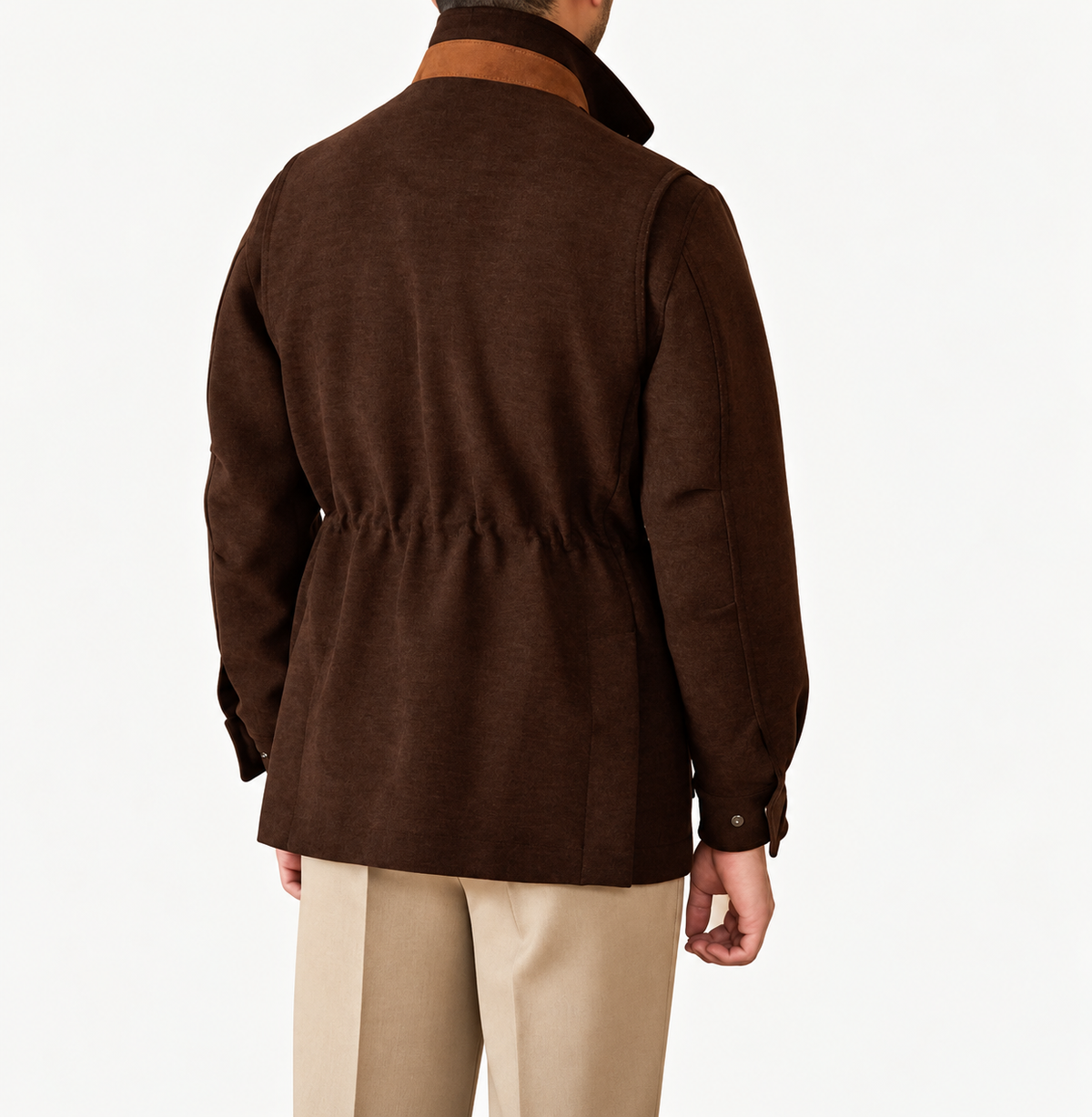 A man viewed from the back wearing a dark brown textured jacket with a contrasting brown collar and beige trousers, set against a plain white studio background.