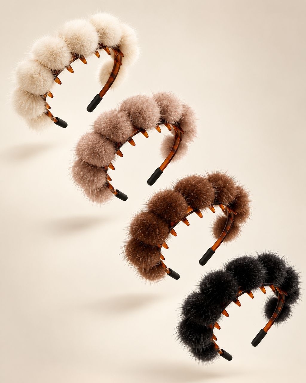 Four fluffy pom-pom headbands in cream, taupe, brown, and black, arranged diagonally on a warm beige background.
