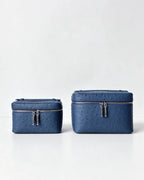Two blue textured zippered cosmetic bags in different sizes, displayed side-by-side on a clean white surface against a light gray background.