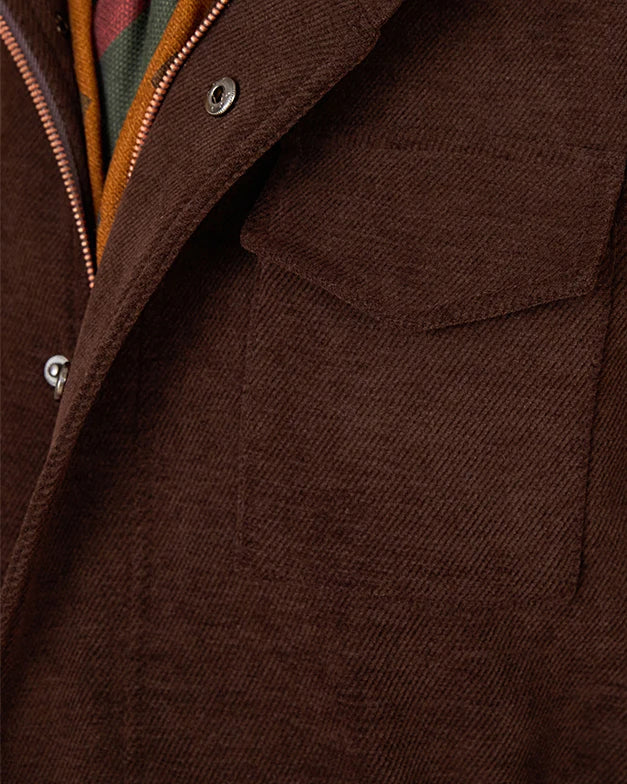 Close-up of a dark brown textured jacket with a zippered collar, silver snap buttons, and a glimpse of a green and orange striped inner lining.