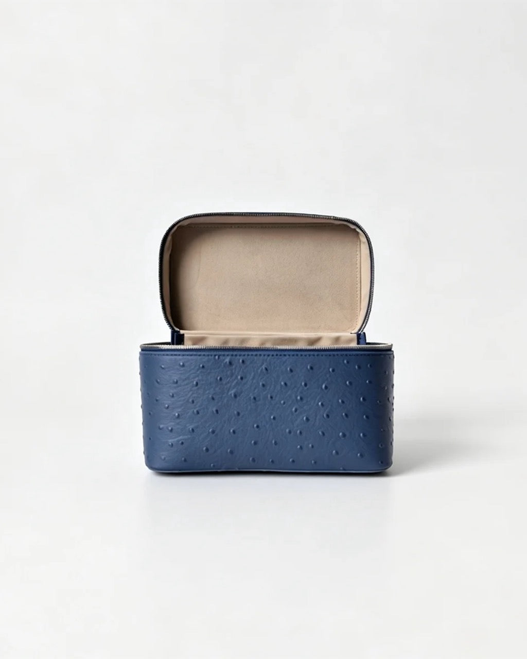 A blue ostrich-textured leather jewelry box with an open lid showing a beige interior, set against a plain white background.