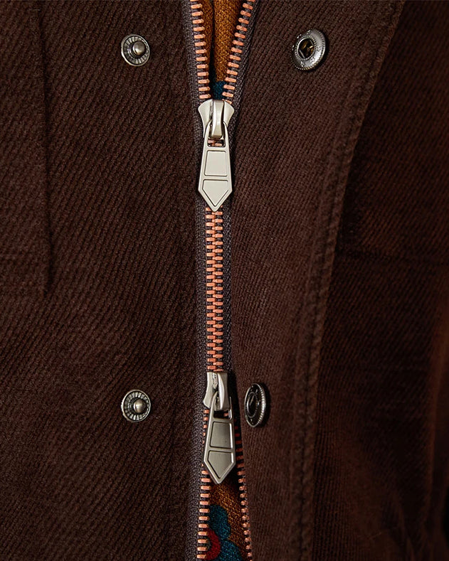 Close-up of a dark brown textured jacket with a silver metal zipper and snap buttons.
