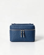 A navy blue faux ostrich leather cosmetic case with silver zipper pulls, photographed on a clean white background.