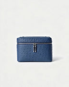 A blue ostrich-textured leather zippered cosmetic case with silver-tone hardware, centered on a clean white background.