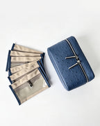 A blue textured zippered cosmetic pouch shown next to a fan of matching beige and blue zippered card slots on a clean white background.