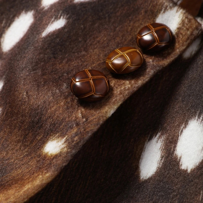 Three dark brown leather shoe covers with gold cross-stitch details, displayed on a brown and white spotted cowhide surface.