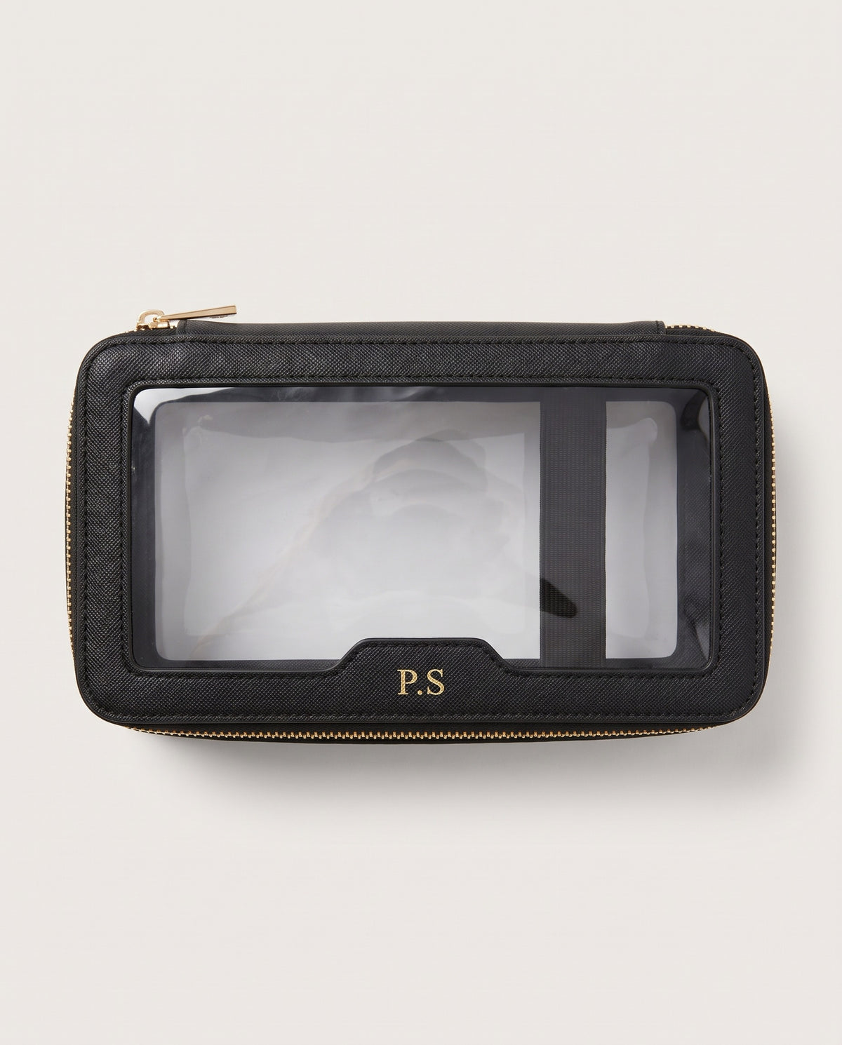 A black textured leather zip-around pouch with a clear plastic ID window and gold-tone hardware, featuring a gold 'P.S' monogram on the front, set against a light off-white background.