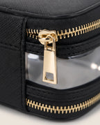 Close-up of a black textured zippered pouch with a clear window and shiny gold zipper pulls.