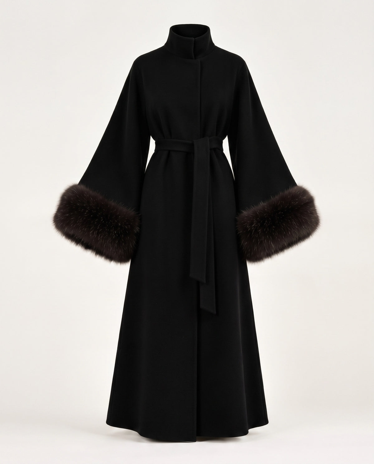 A long black wrap coat with a high collar, wide sleeves, and dark brown fur trim at the cuffs, shown on a plain light background.