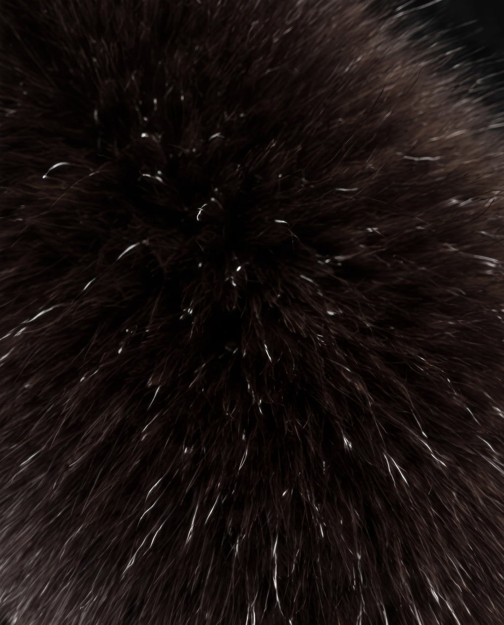 A close-up texture shot of a dark brown faux fur or fox fur material with subtle silver-white highlights.