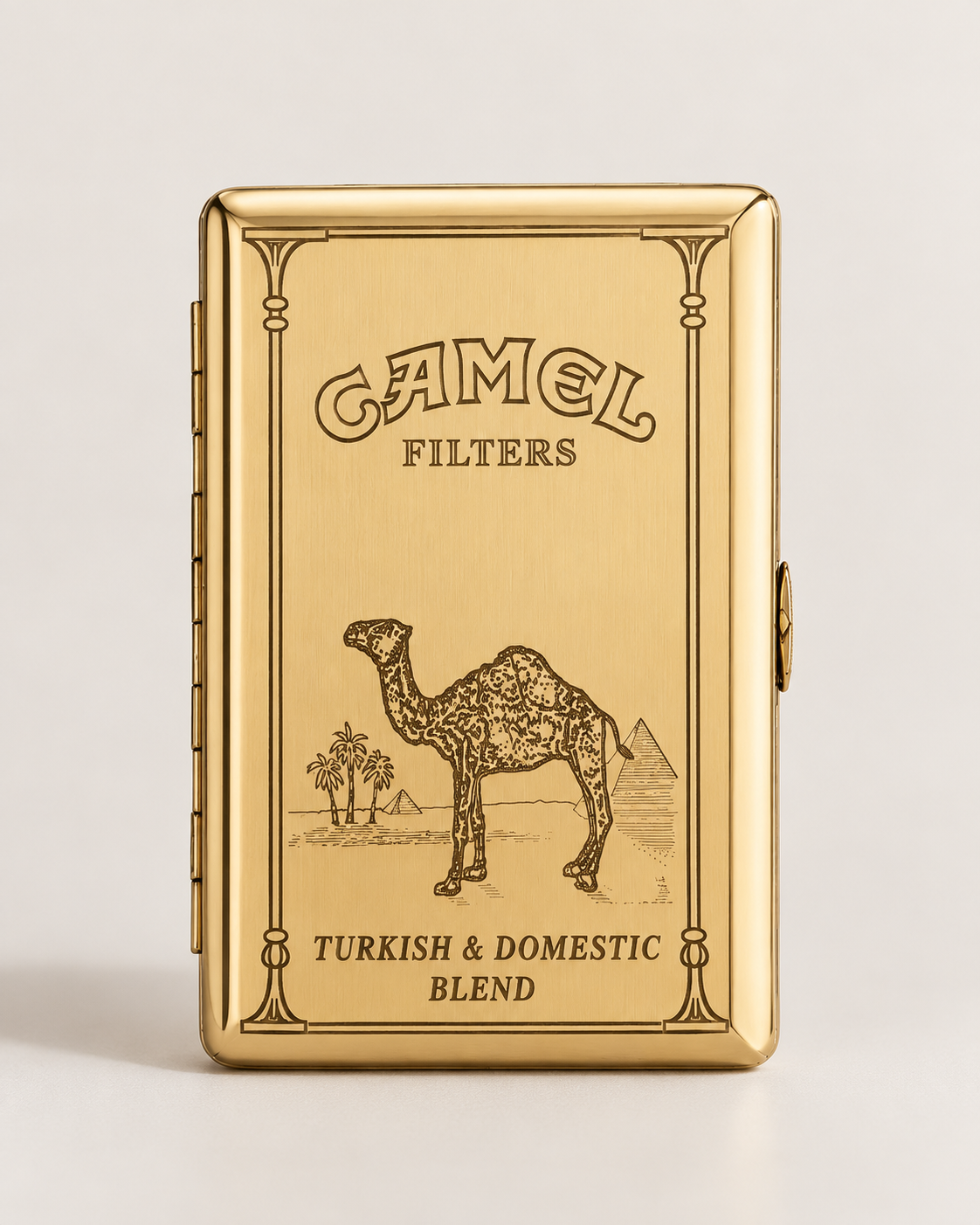 A gold-toned Camel Filters tin for Turkish & Domestic Blend, featuring an engraved camel illustration and branding on a light gray background.