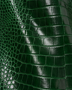 Close-up of the glossy green croc embossed leather on The Riviera Leather Trench
