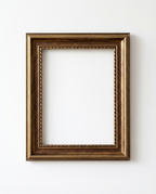 An empty rectangular picture frame with an ornate rope-like inner border and a distressed bronze-brown finish, mounted on a plain white wall.