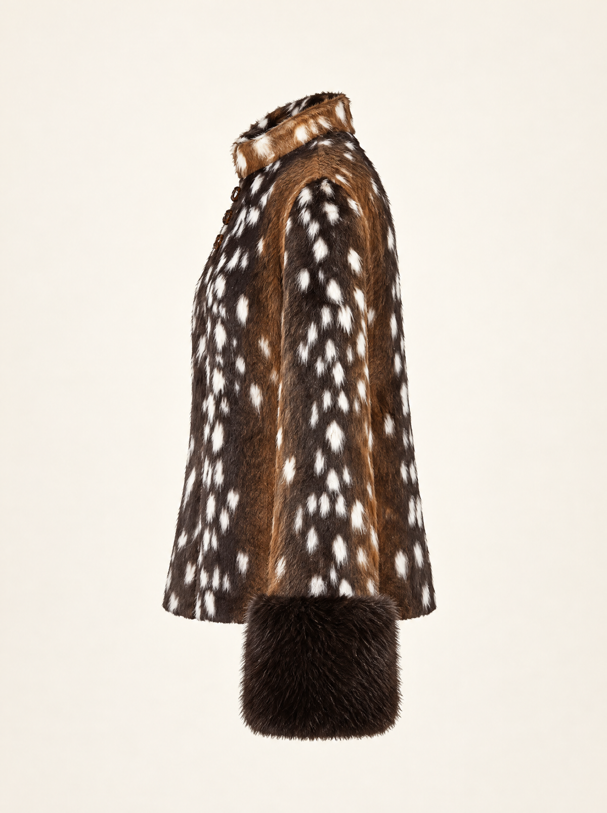 A side-profile view of a brown and white spotted fur coat with a dark brown fur cuff, set against a solid off-white background.