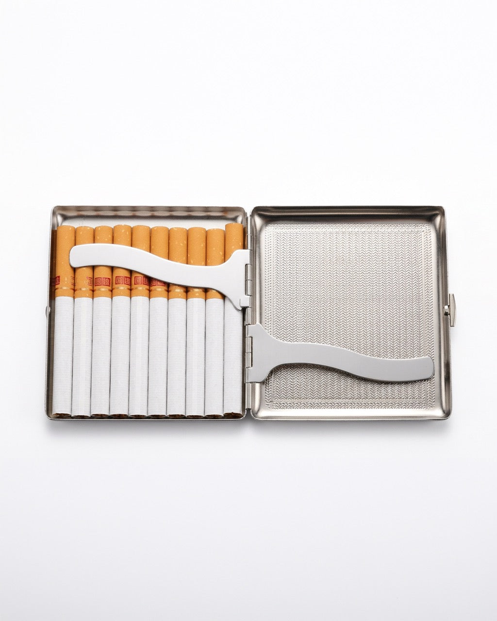 A stainless steel cigarette case shown open on a white background, containing several cigarettes in a left compartment and a silver metal cigarette cutter resting across the divider.