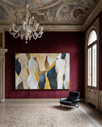 A large framed abstract painting with cream, gold, navy, and burgundy shapes hangs on a deep burgundy velvet wall in an ornate gallery room with a chandelier, terrazzo floor, and a black leather armchair.