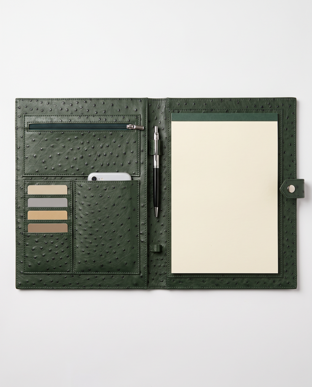 An open dark green ostrich-textured leather organizer cover on a light gray background. The cover contains a zippered pocket, card slots with beige and gray cards, a pen, and a cream-colored notepad.