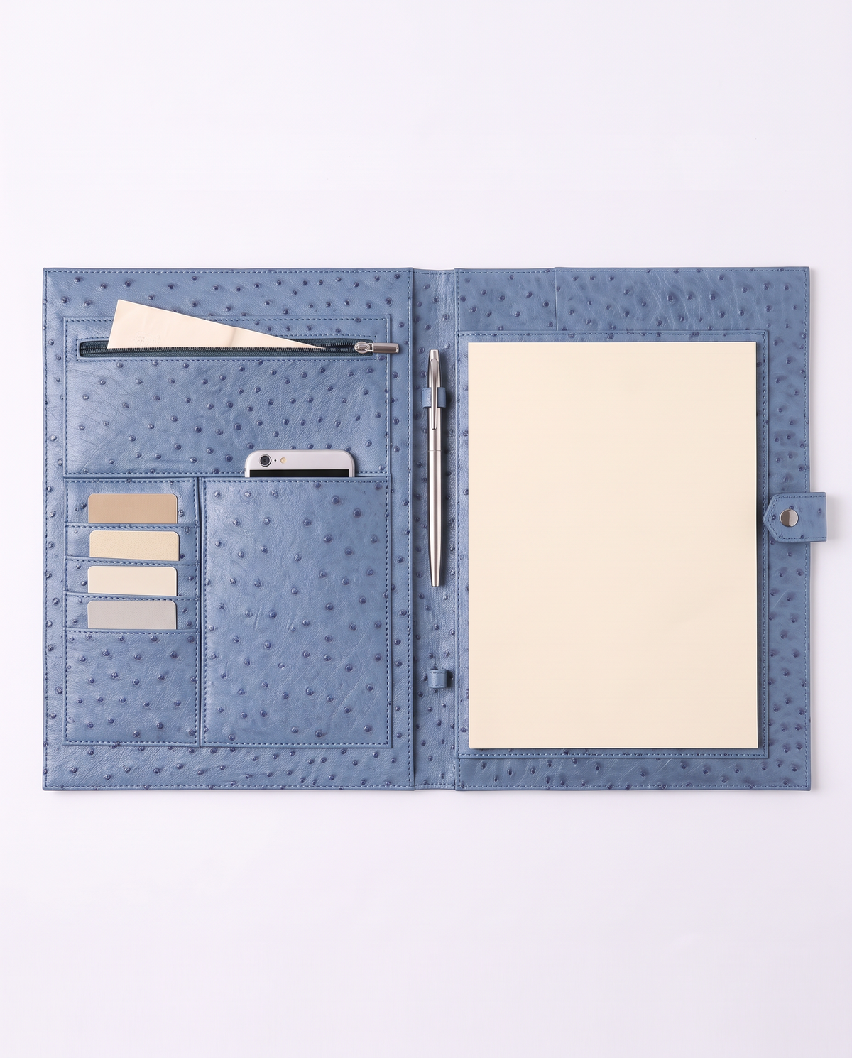 A blue ostrich-textured leather notebook cover shown open on a white background, featuring card slots, a pen loop, a pen, and a blank cream-colored notepad page.
