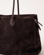 Close-up of the Dark Coffee suede, leather handle tab and side zip on The Marais Tote