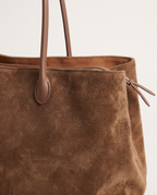 Close-up of the Brown suede, leather handle tab and side zip on The Marais Tote