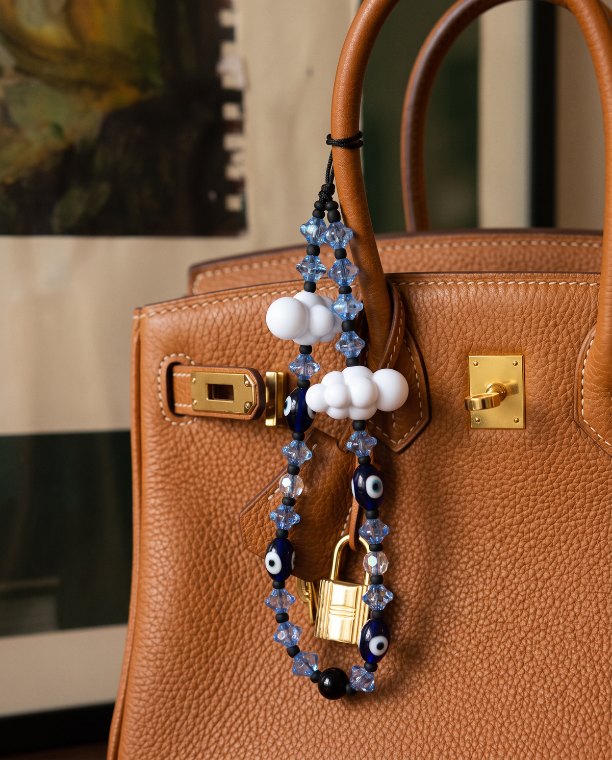 Close-up of The Daydream strap looped over a tan leather bag handle