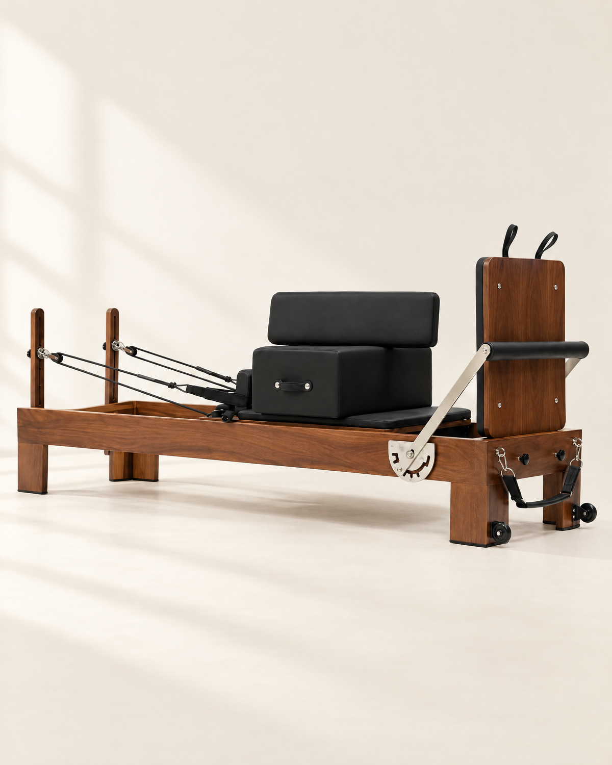 The Pavilion Reformer in walnut with black upholstery and sitting box