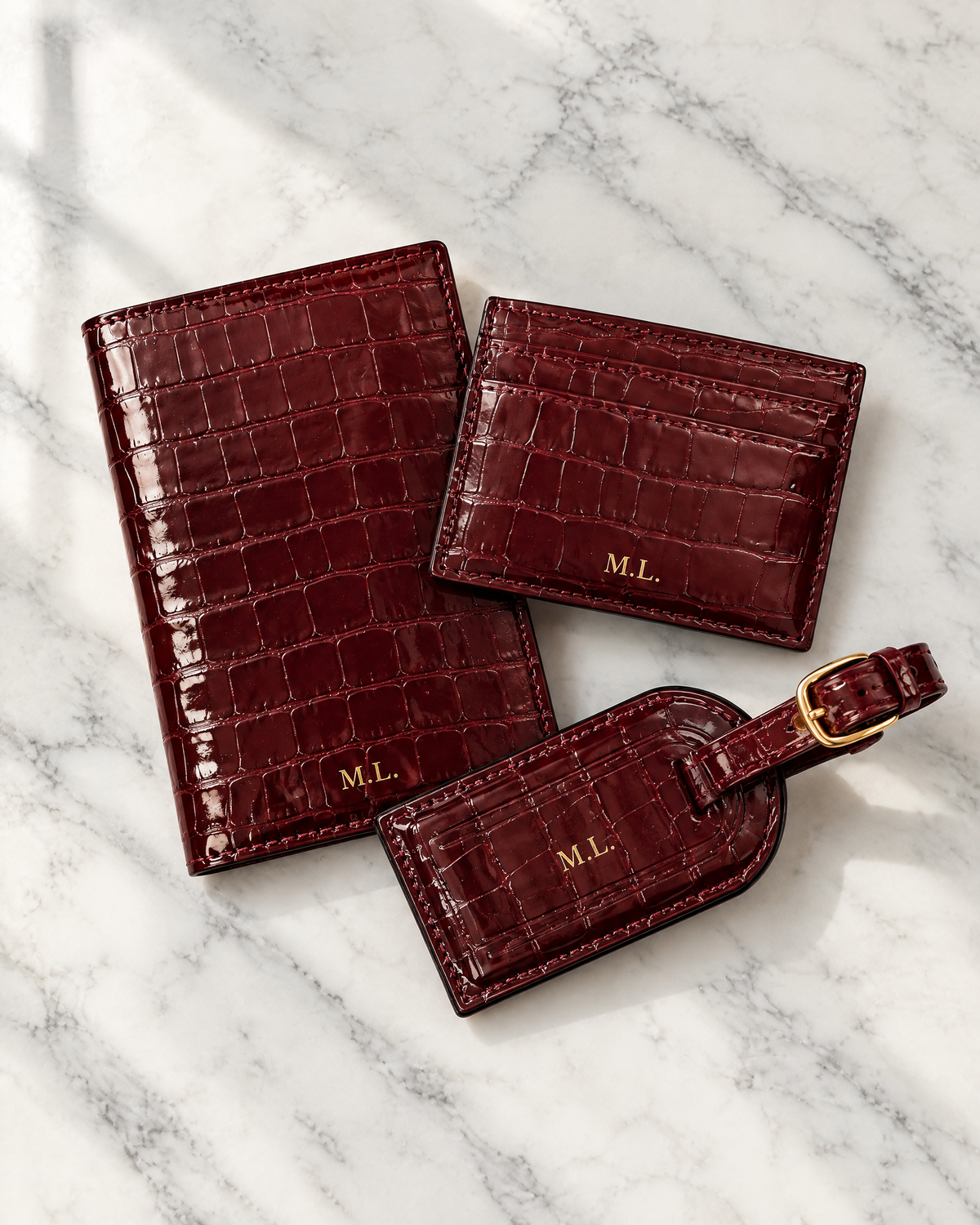 The Grand Voyage Travel Set in Croc Burgundy on a marble table