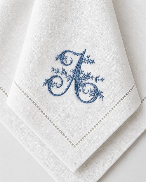 The Belle Époque Napkin, close-up of an embroidered floral initial on a hemstitched napkin corner