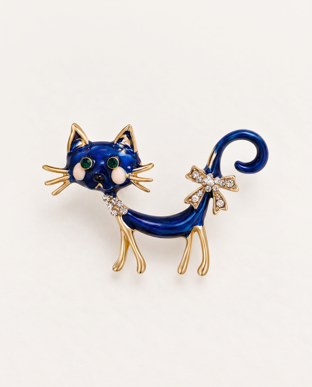 The Midnight Cat Brooch in blue enamel and gold on an off-white background