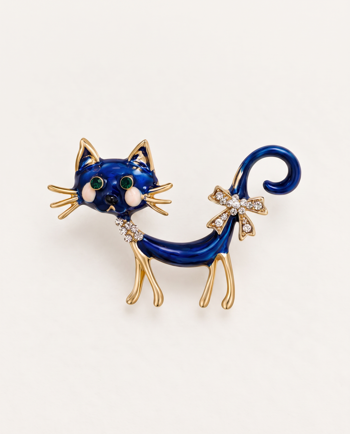 The Midnight Cat Brooch in blue enamel and gold on an off-white background