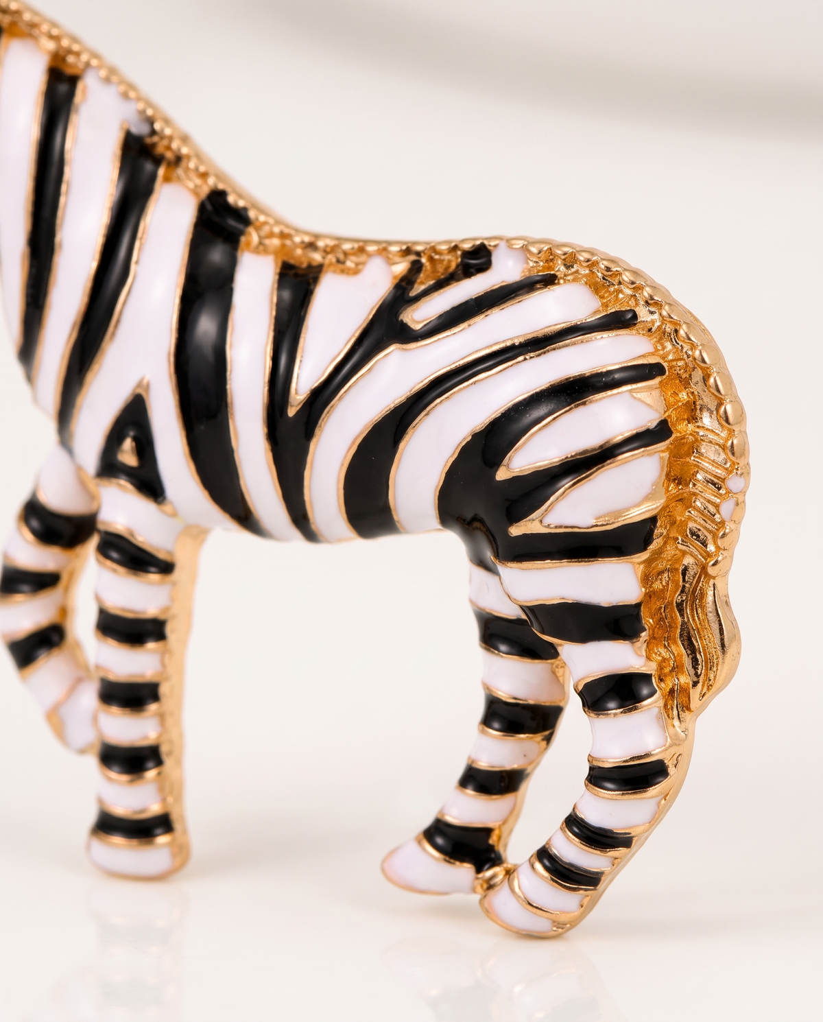 Close up of the beaded gold mane and striped enamel body