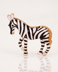 The Zebra Brooch standing with a soft reflection