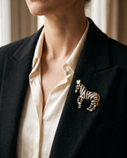 The Zebra Brooch worn on the lapel of a black blazer