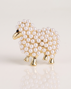The Pearl Lamb Brooch standing with a soft reflection