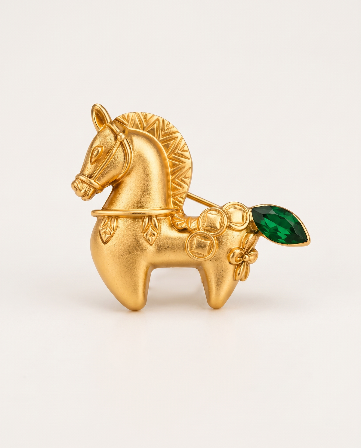The Lucky Pony Brooch in matte gold with a green crystal tail