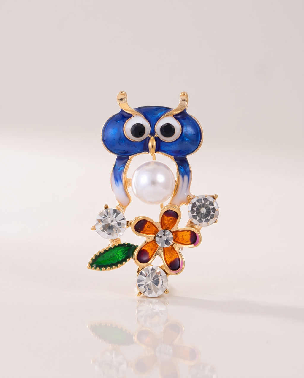 The Garden Owl Brooch standing with a soft reflection