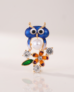 The Garden Owl Brooch standing with a soft reflection