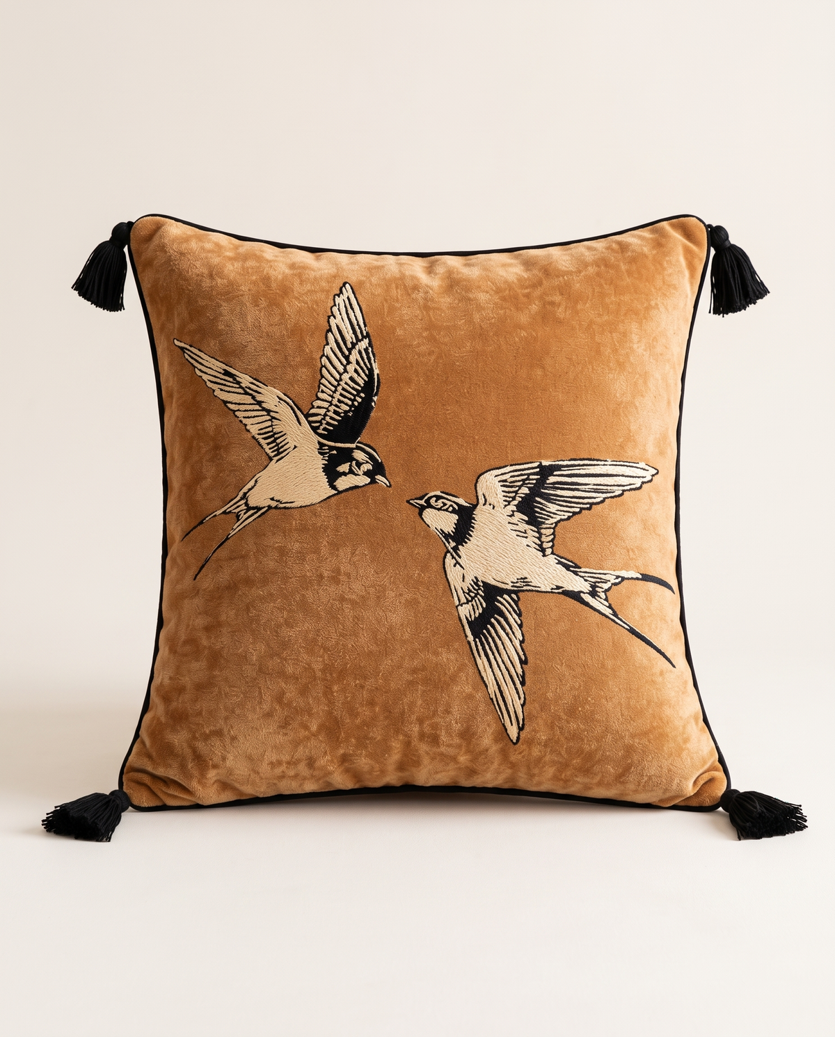 The Migration Cushion in camel velvet with embroidered swallows