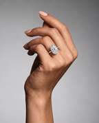 Raised hand wearing The Duchess Ring against a soft grey background