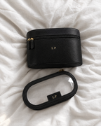 The Riviera Vanity Case in black with gold initials on off-white linen