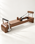 The Belgravia Reformer in solid walnut with tan upholstery and stainless steel footbar