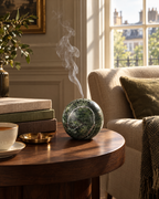 The Carrara Incense Sphere burning on a walnut side table