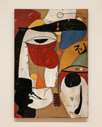 A cubist-style abstract painting on canvas featuring geometric forms, a stylized face, and bold blocks of red, black, white, blue, beige, and orange, shown hanging against a light neutral wall.