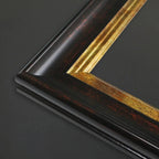 Close-up of a picture frame corner showing a dark brown wood-grain finish with a prominent gold inner trim on a dark gray background.